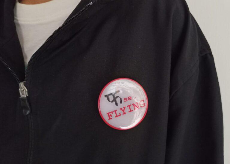 Image of Pin Badge 'Pha Se Flying' Hindi Quote Grey on Jacket