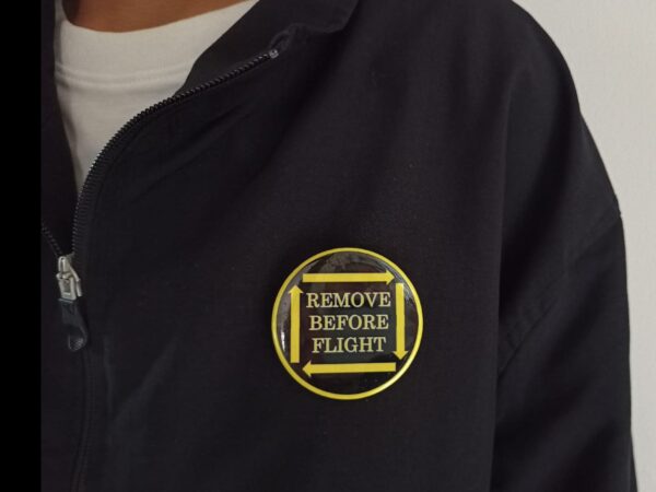 Pin Badge 'Remove Before Flight' Black Yellow with Arrows on Jacket