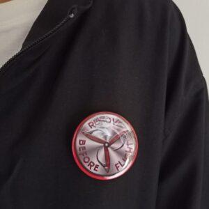 Image of Pin Badge 'Remove Before Flight' Silver Red Metallic with 3 Blade Prop on Jacket