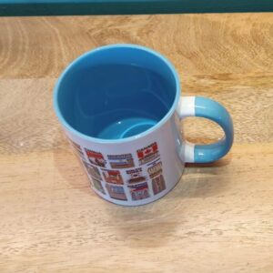 Ceramic Mug with Tourist Flags of Various Countries Light Blue Top View
